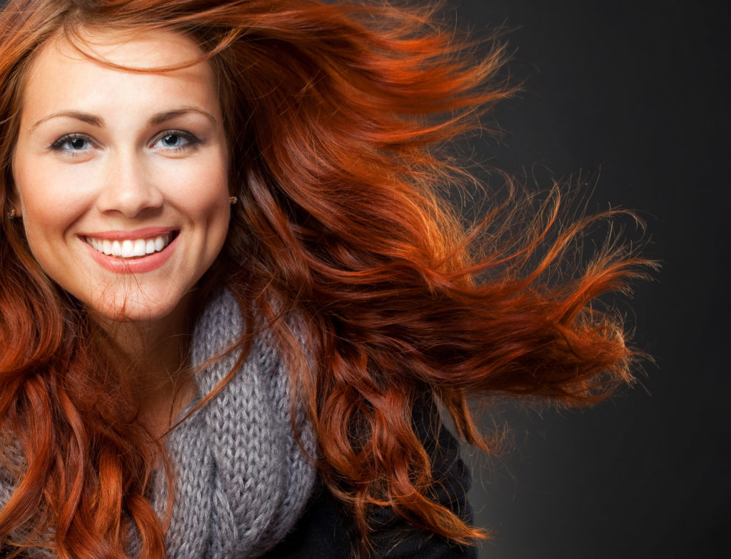 Close-up of beautiful woman face with red curly hair